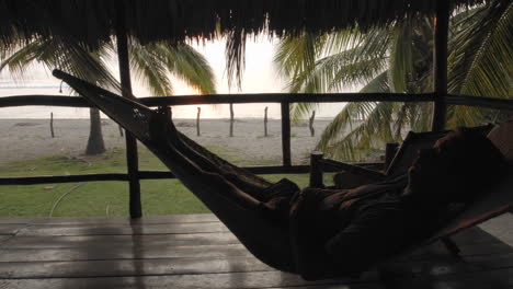 Zeitraffer-Eines-Mannes,-Der-In-Einer-Hängematte-In-Palapa-Am-La-Saladita-Beach-Guerrero-Mexiko-Sitzt