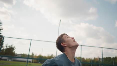 young athlete throws volleyball up and slams it into the distance, with blurred background of people in outdoor sports arena, high energy action shot on court with focus on skill