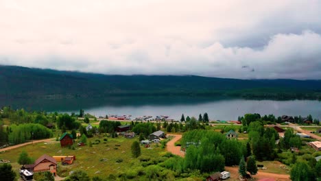 drone reviel of a beautiful mountain lake with cloudy hills and a peaceful clear body of water