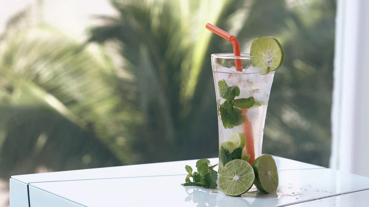 얼어붙은 음료는 흐릿한 손바닥에  ⁇  테이블에 서 있습니다.