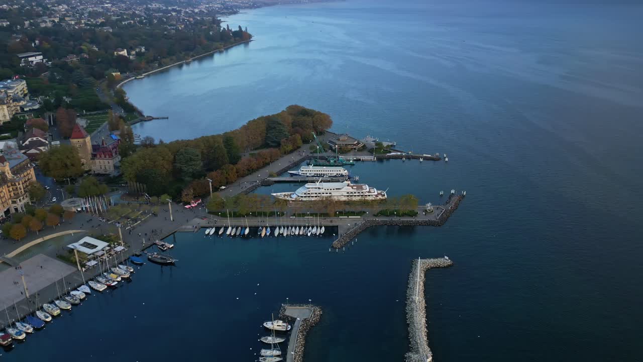 Orbit drone shot of Ouchy Port with huge white boat at sunset in Lausanne Switzerland