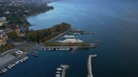 orbit drone shot of ouchy port with huge white boat at sunset in lausanne switzerland