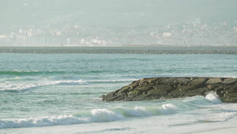 Tidal Waves Against Breakwater With Misty City Landscape At Figueira da Foz, Portugal