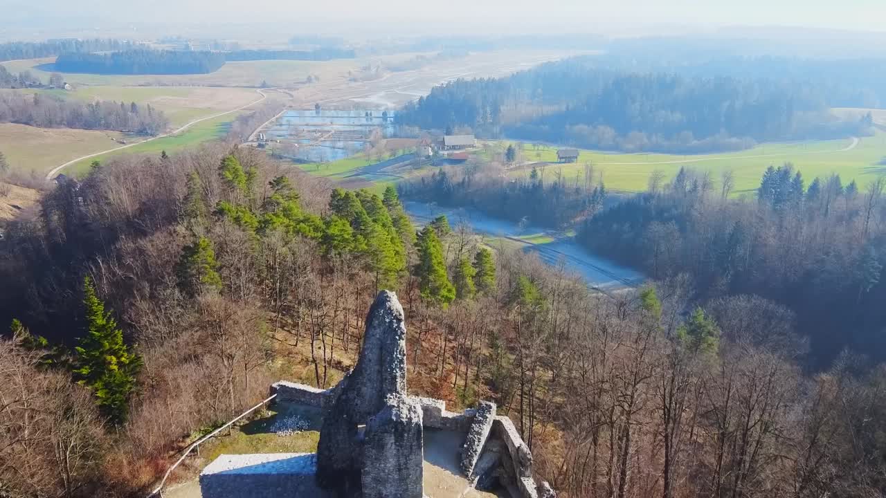 fly over Zovnek castle, Braslovce, Slovenia, revealing Lake Zovnek and forest