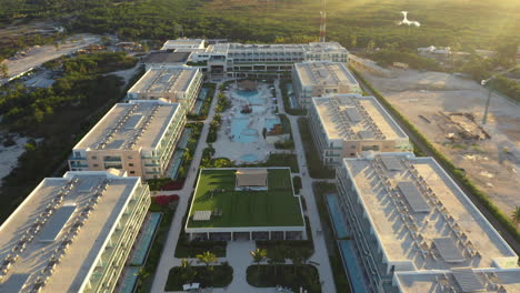 gloden light streams across a luxury resort near punta cana, dominican republic, aerial fly over