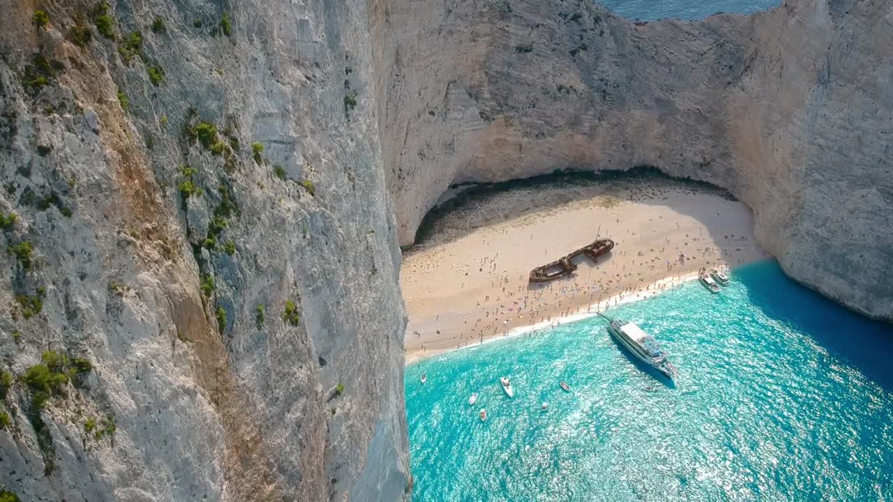imágenes aéreas de turistas que visitan la bahía del naufragio, la playa de navagio, zakynthos, grecia