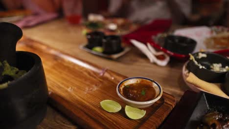 beef fajitas with peppers and onions on a hot plate, surrounded by tortillas and sauces, in a warm restaurant setting