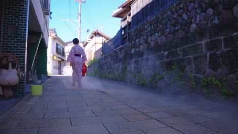 japanese women in yukata walking through geothermal street, beppu
