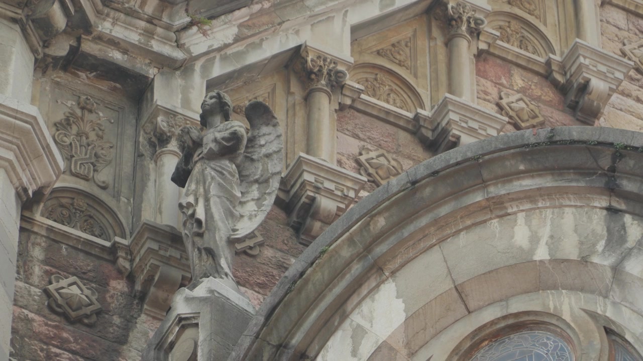 Primo piano di una scultura di angelo ornata sull'esterno in pietra consumata di una cattedrale a Oviedo