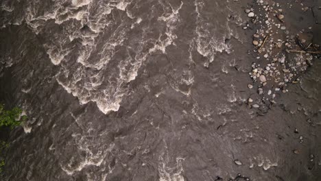 top down view of fast flowing brown waters of río peñas blancas in costa rica's north west