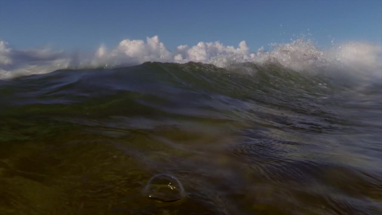 Water level view of waves crashing and rolling into shore
