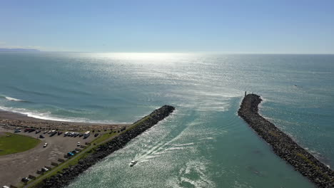 Boat-entering-harbor.-Brookings,-Oregon.-Aerial-flying-backwards