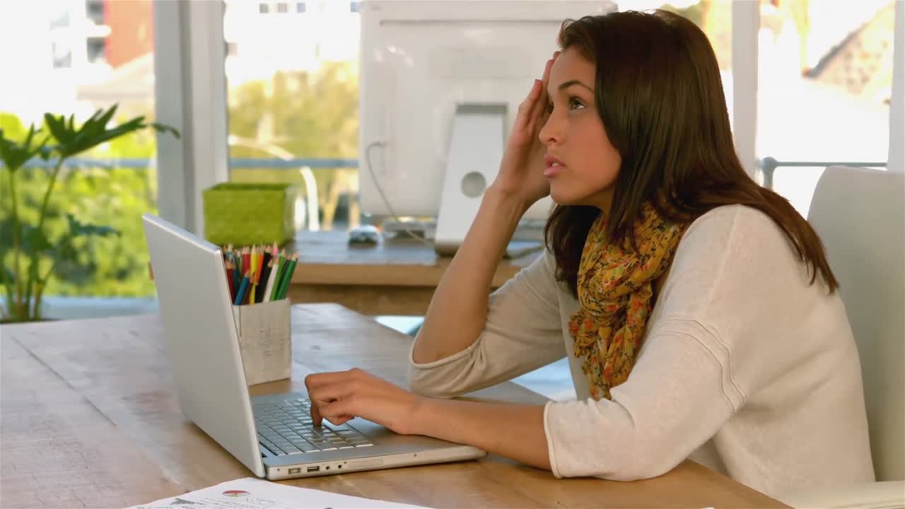 una chica bonita centrándose en su portátil.