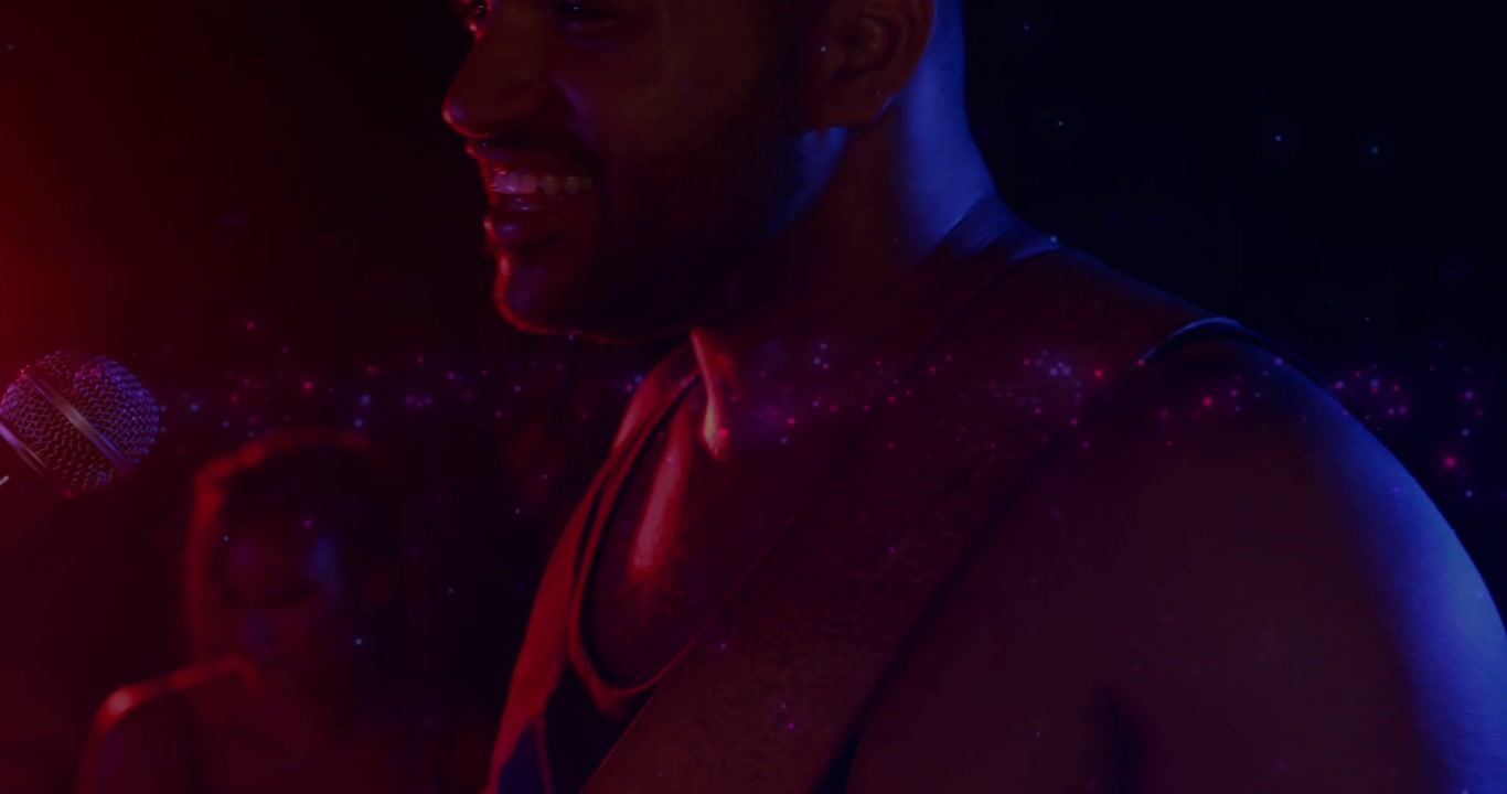 Singing man wearing tank top, guitar strap, leaning into mic starting song at small club, sparkles