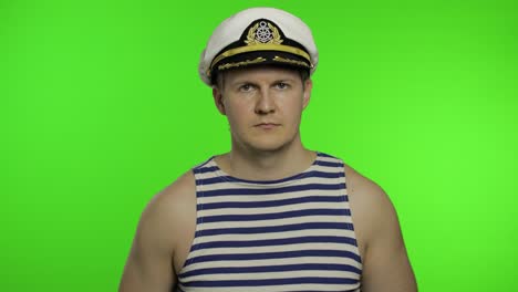 young sailor man salutes with hand to camera. seaman guy in sailor's vests