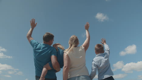 A-young-family-greeting-a-plane-flying-above