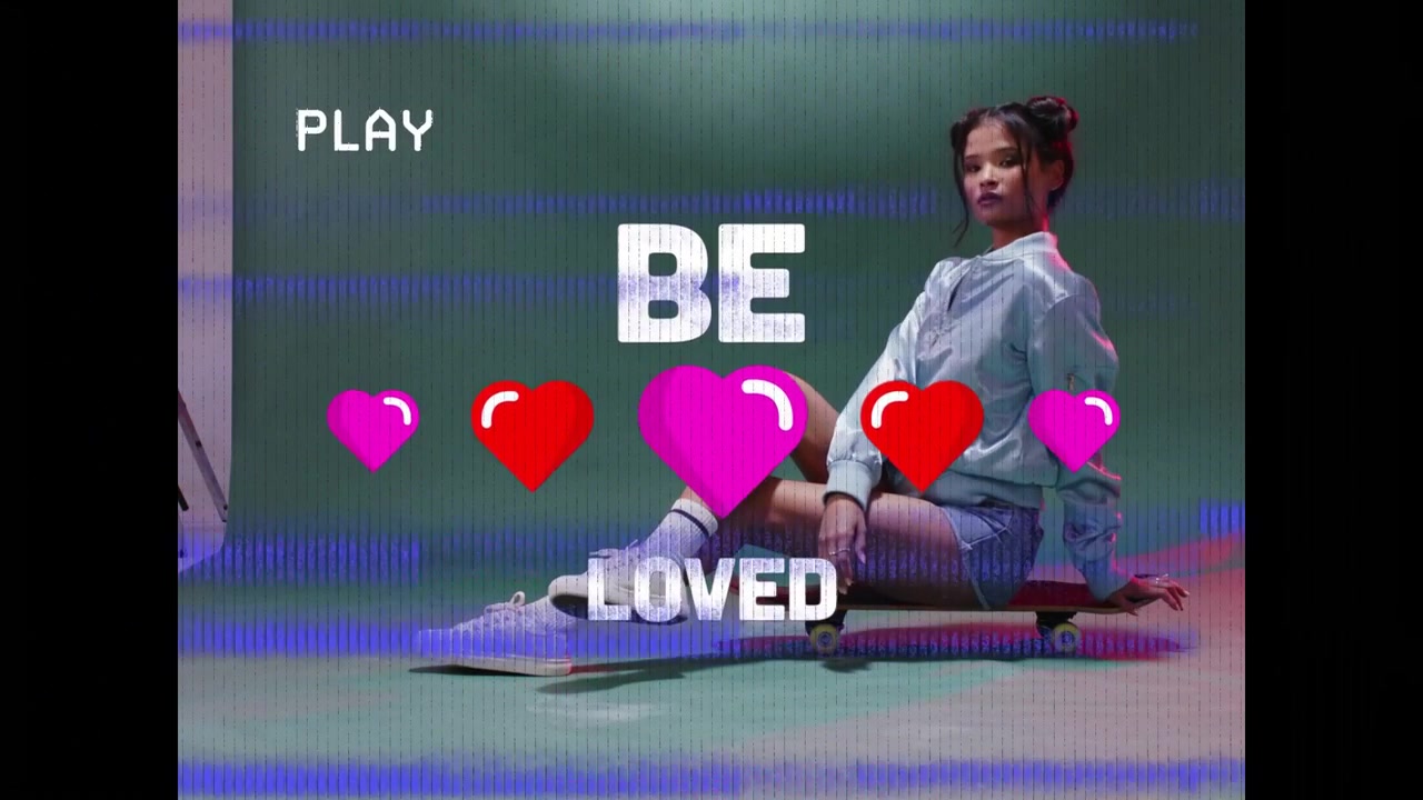 Vertikales Video: Posierendes Model in blauer Jacke auf Skateboard richtet sich aus, während BE LOVED Herzen animieren