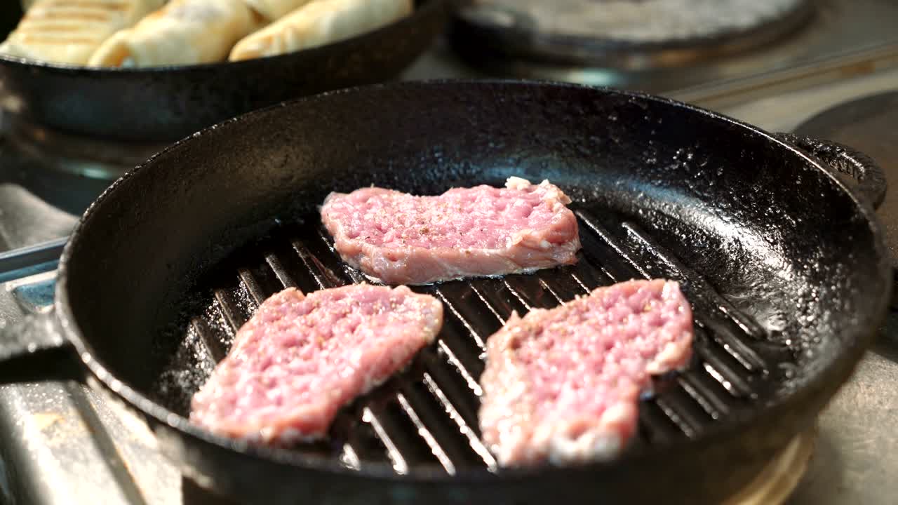 셰프는 그릴 팬에서 맛있는 고기를 준비합니다.