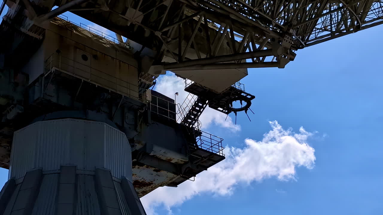 Close-up view of a large industrial crane against a blue sky