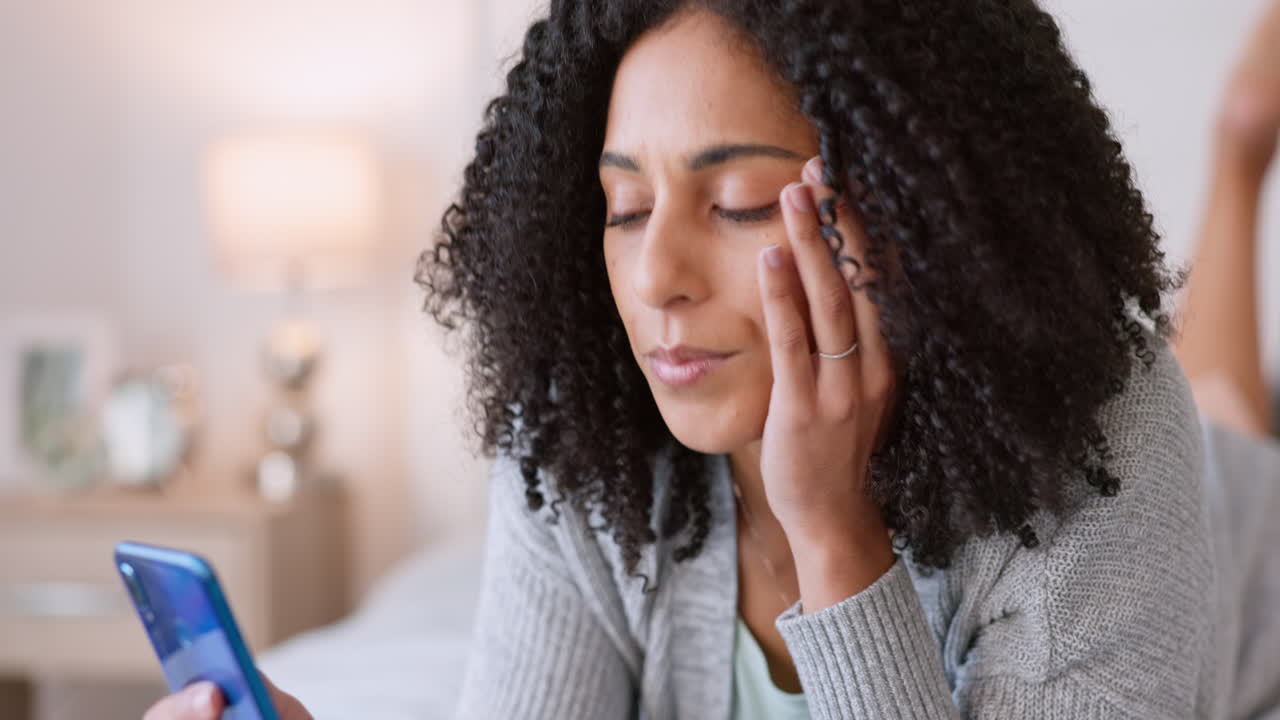 Tired woman relax on a bed with a phone broswing