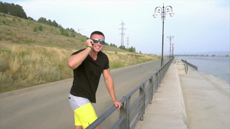 man talking on phone near the river