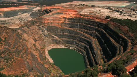 drone shot of an abandoned mine pit in the foreground and a mining site in the background in western australia