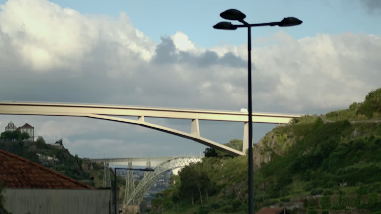 un coche blanco que está conduciendo sobre uno de los puentes más delgados en porto, portugal