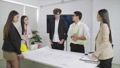 team of engineers are having a brainstorming meeting in the conference room.