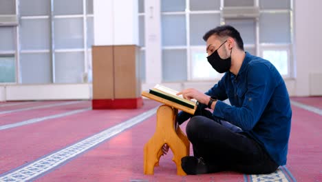 Hombre-Con-Máscara-Recitando-La-Mezquita-Del-Corán