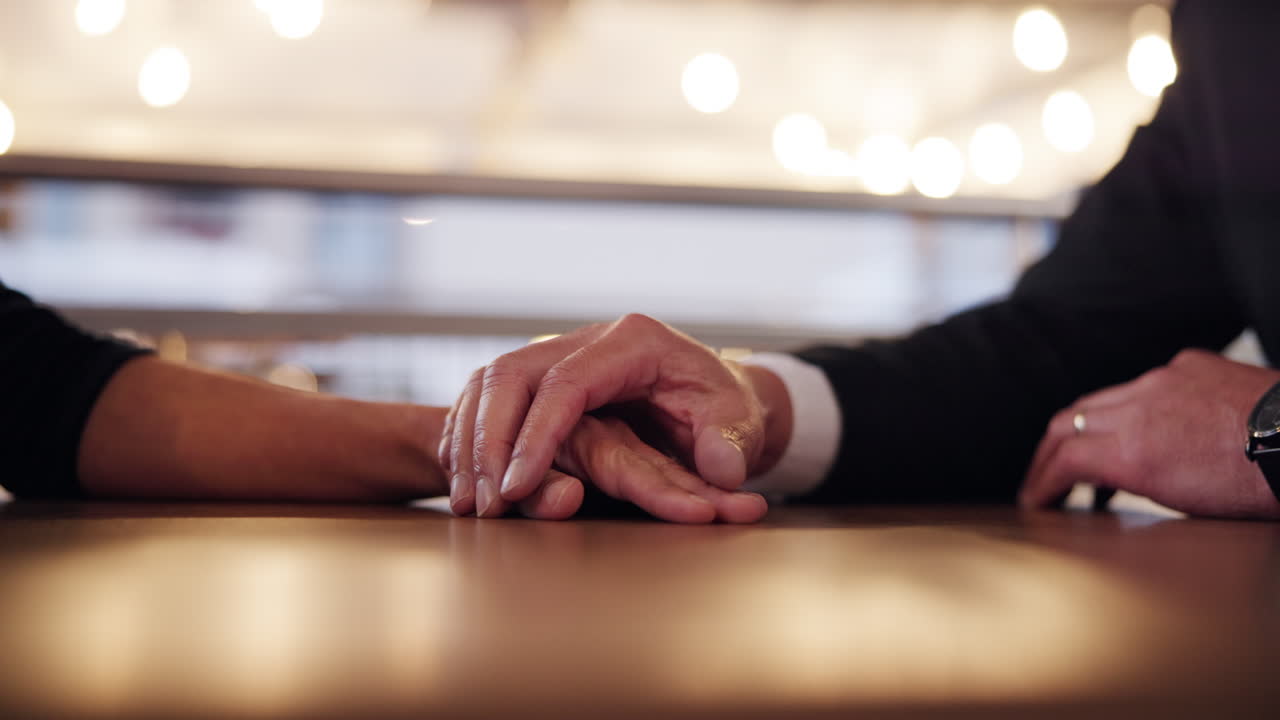 Couple Holding Hands at a Table