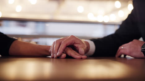 Couple Holding Hands at a Table