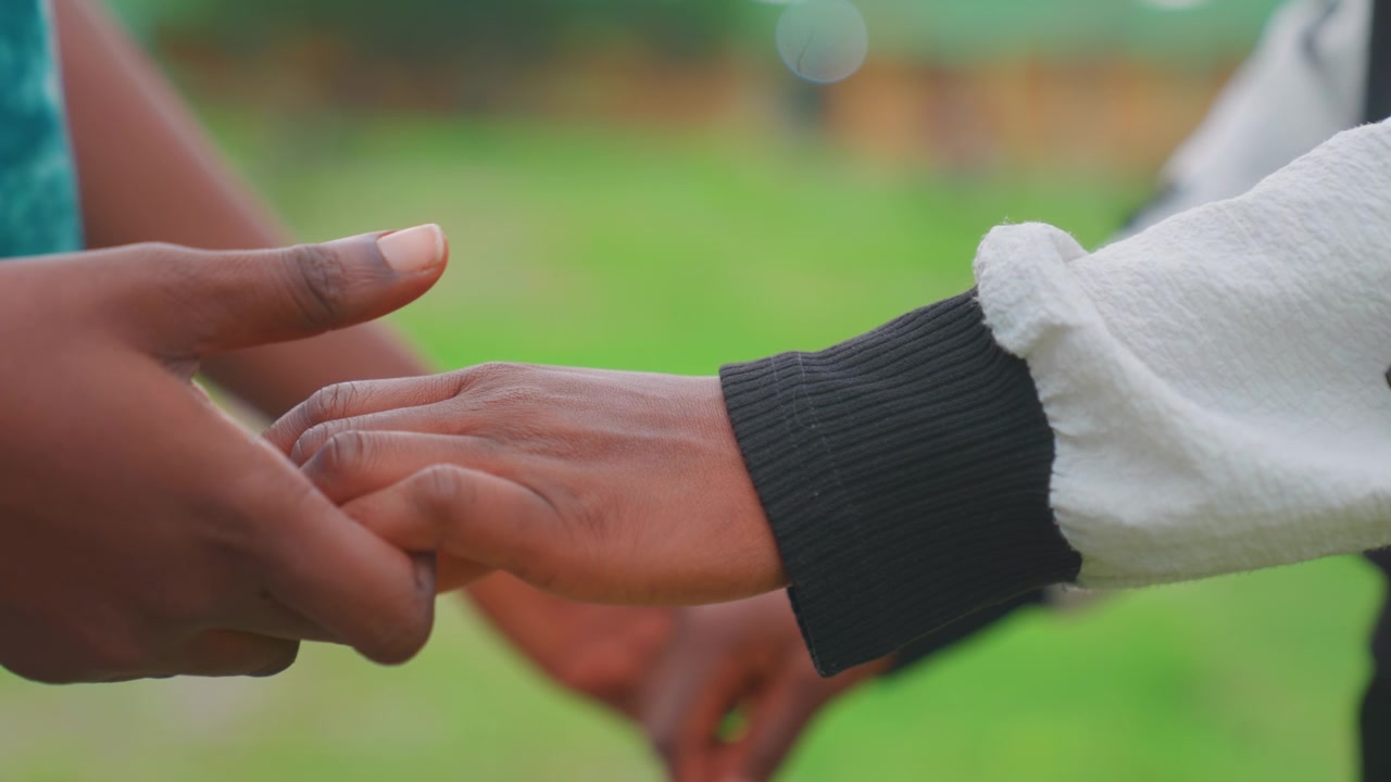 Parenting tender embrace. Emotional connection through gentle handholding in natural setting. Intimate moment of maternal affection captured through clasped hands during peaceful park visit