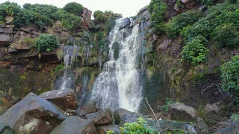 Aerial-drone-footage-of-a-tall-rocky-waterfall-in-the-Yorkshire-Dales,-Pennies