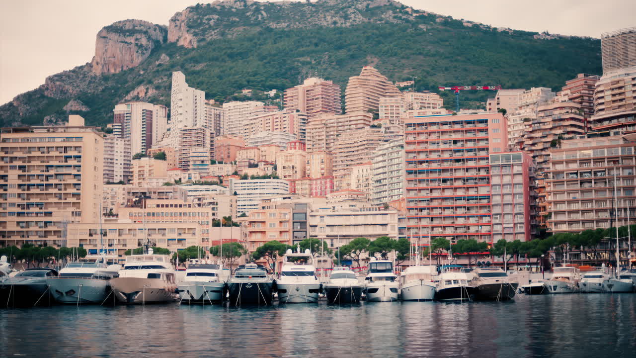 View of boats docked in the Monaco Marina with the skyline of the city on the background