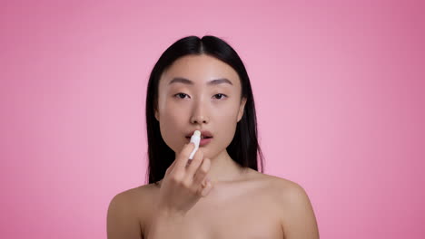 mujer aplicando bálsamo labial