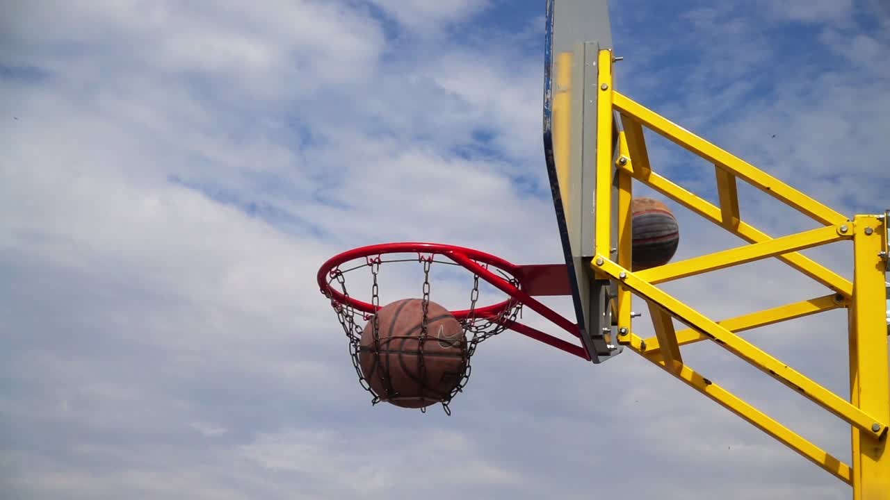 Pallacanestro da strada. La palla vola verso il canestro. Al rallentatore