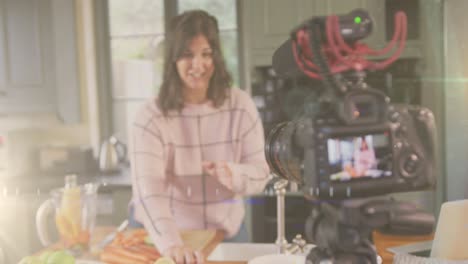 animación de luz brillante sobre la cámara con una vlogger femenina grabando un vlog culinario en casa