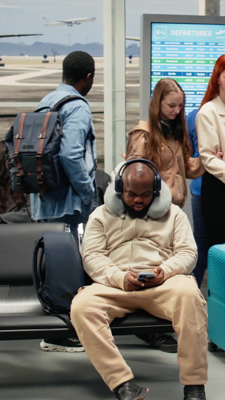 Vertical video Carrying trolleys, plane traveling and tourists in airport lounge going on trip