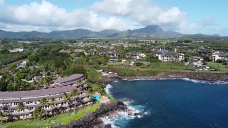 Aerial-Drone-Video-capturing-oceanfront-resort-hotels,-beach,-blue-ocean-and-mountain-landscape