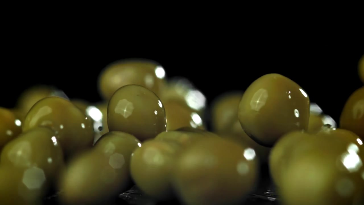 Friske grønne ærter falder i slowmotion