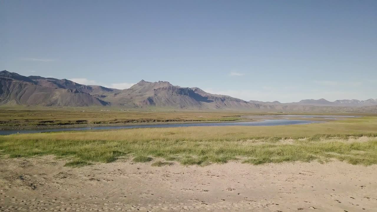 imágenes aéreas de una rara playa de arena dorada y un río durante el verano soleado en la península de snaefellsness, islandia