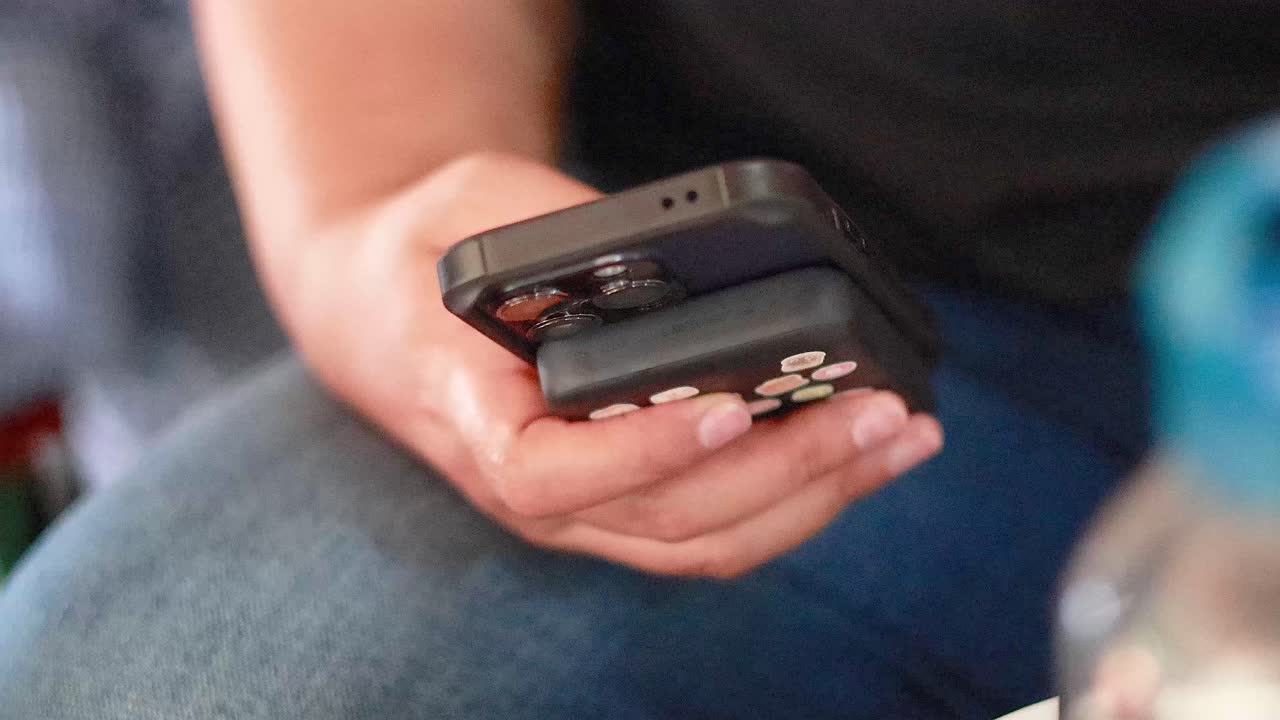 persona que utiliza un teléfono inteligente en un mercado flotante