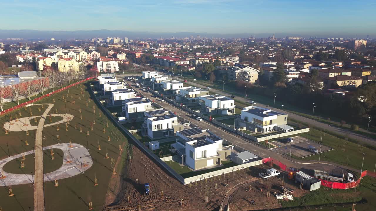 Vista aerea di un drone su un complesso residenziale futuristico con architettura eco-compatibile. Case moderne a basso impatto, design sostenibile e pianificazione urbana pulita in condizioni di luce diurna nitida