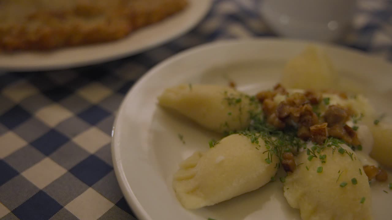 Patate, cotoletta e zuppa a pranzo su tovaglia a quadri, ristorante