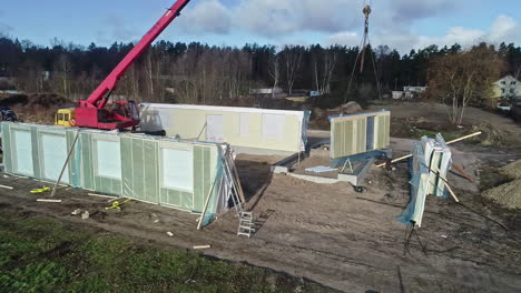 modular home assembly on construction site with crane