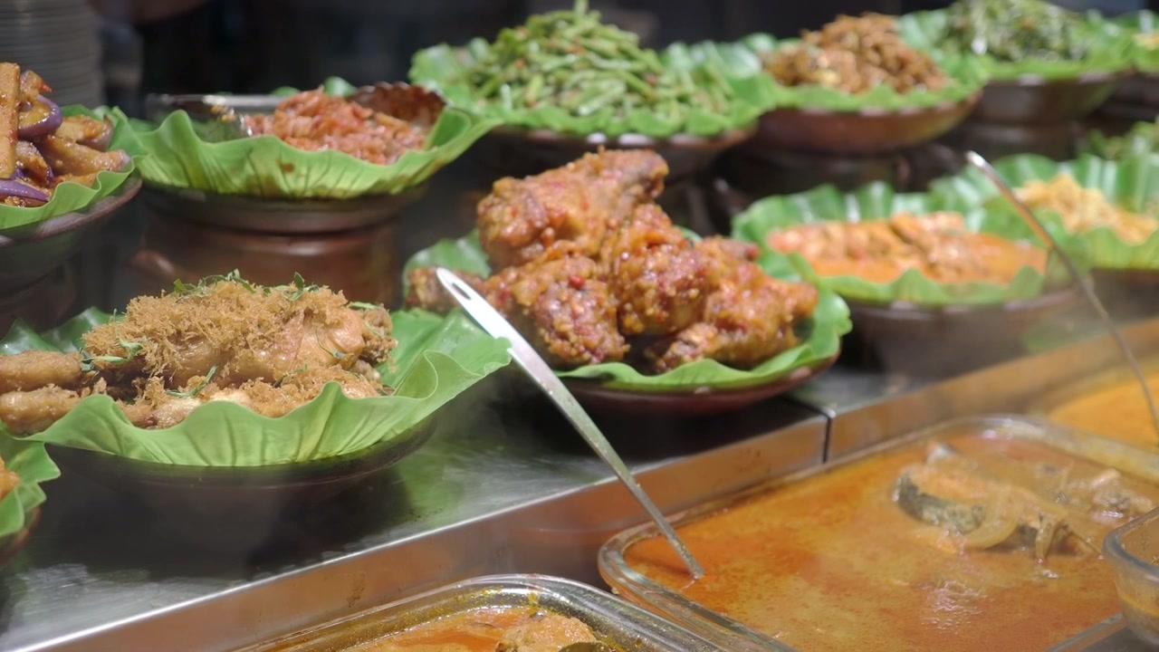 Piatti tradizionali indonesiani assortiti esposti in una bancarella di cibo
