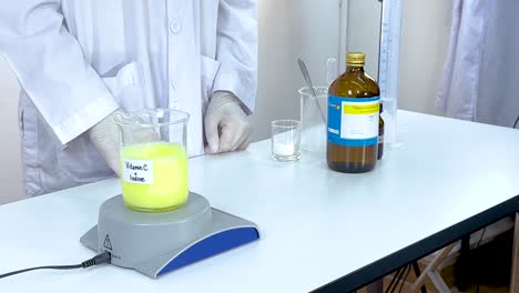 a scientist conducts an iodine clock reaction using vitamin c and starch, demonstrating chemical change in a lab setting