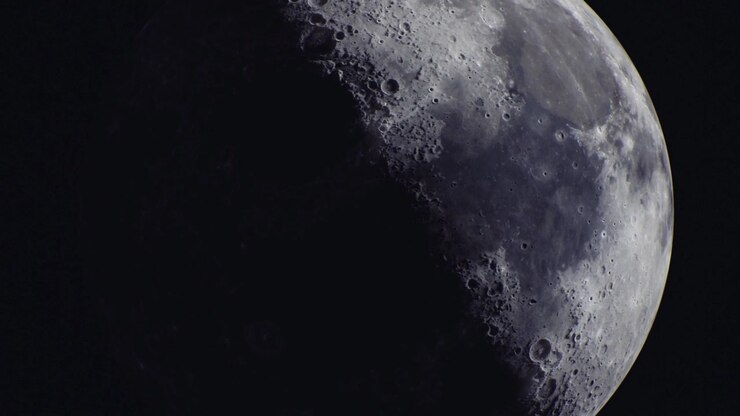 Vista majestosa da superfície da lua com crateras e sombras à noite