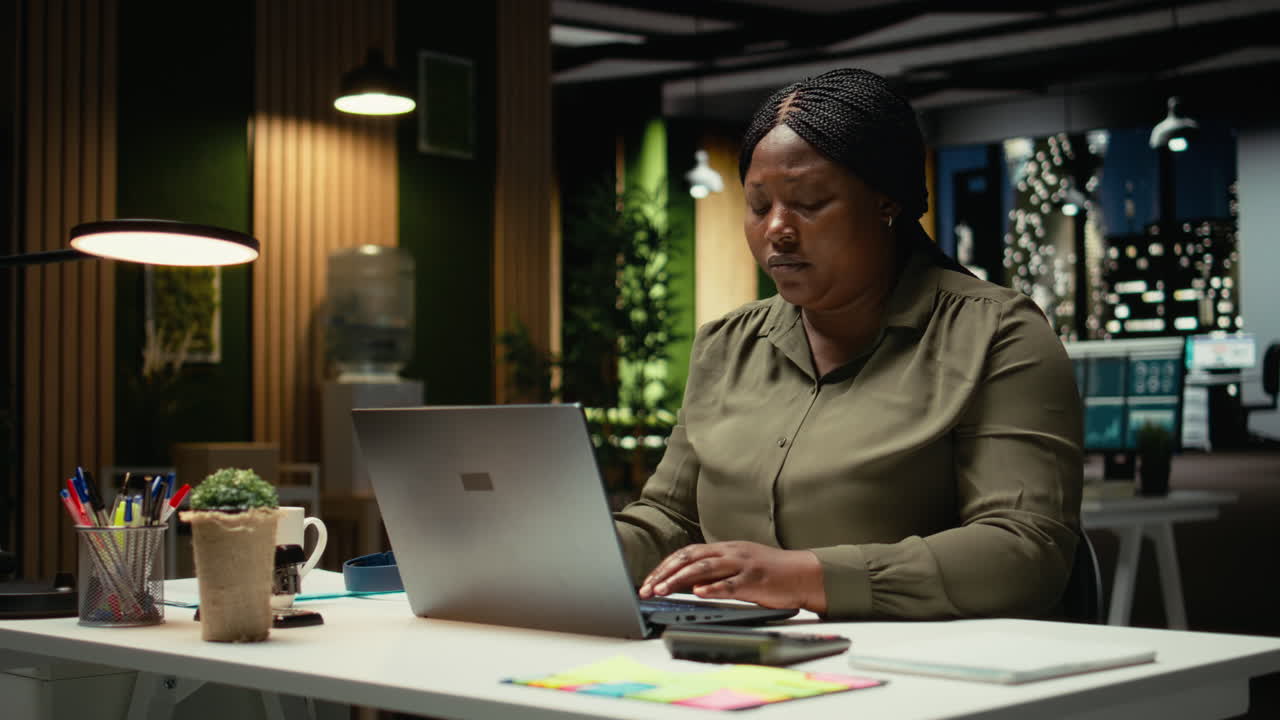 African american person playing with a pen at the office in deep contemplation