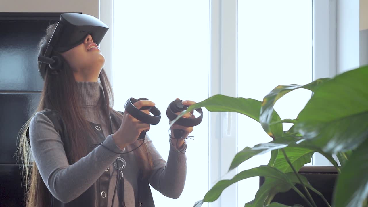 La bella ragazza che gioca con un visore di realtà virtuale in ufficio
